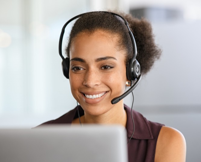 Woman Working on a Laptop Wearing a Headset Woman Working on a Laptop Wearing a Headset