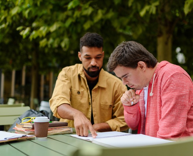 Young Man with down Syndrome Studyng with Special Educator Teacher